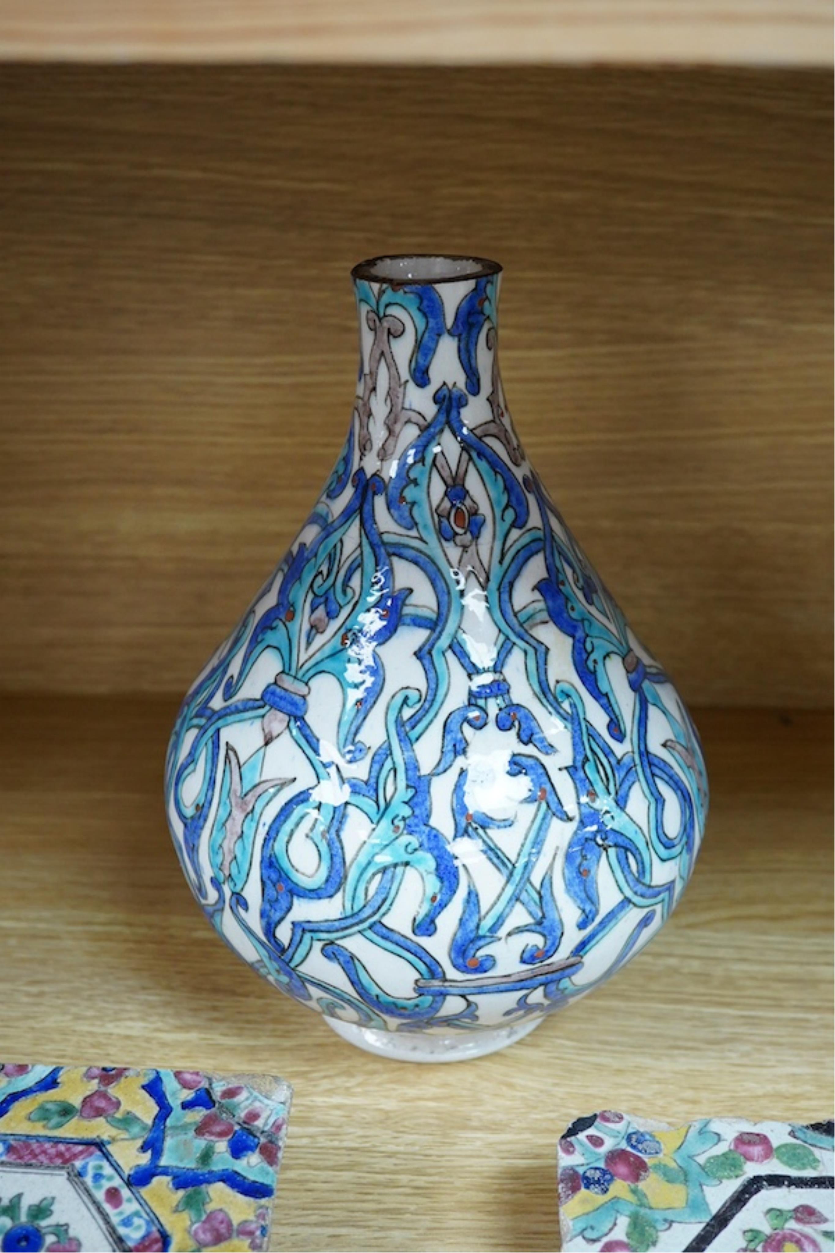 A Persian stoneware vase (reduced) and two floral tiles